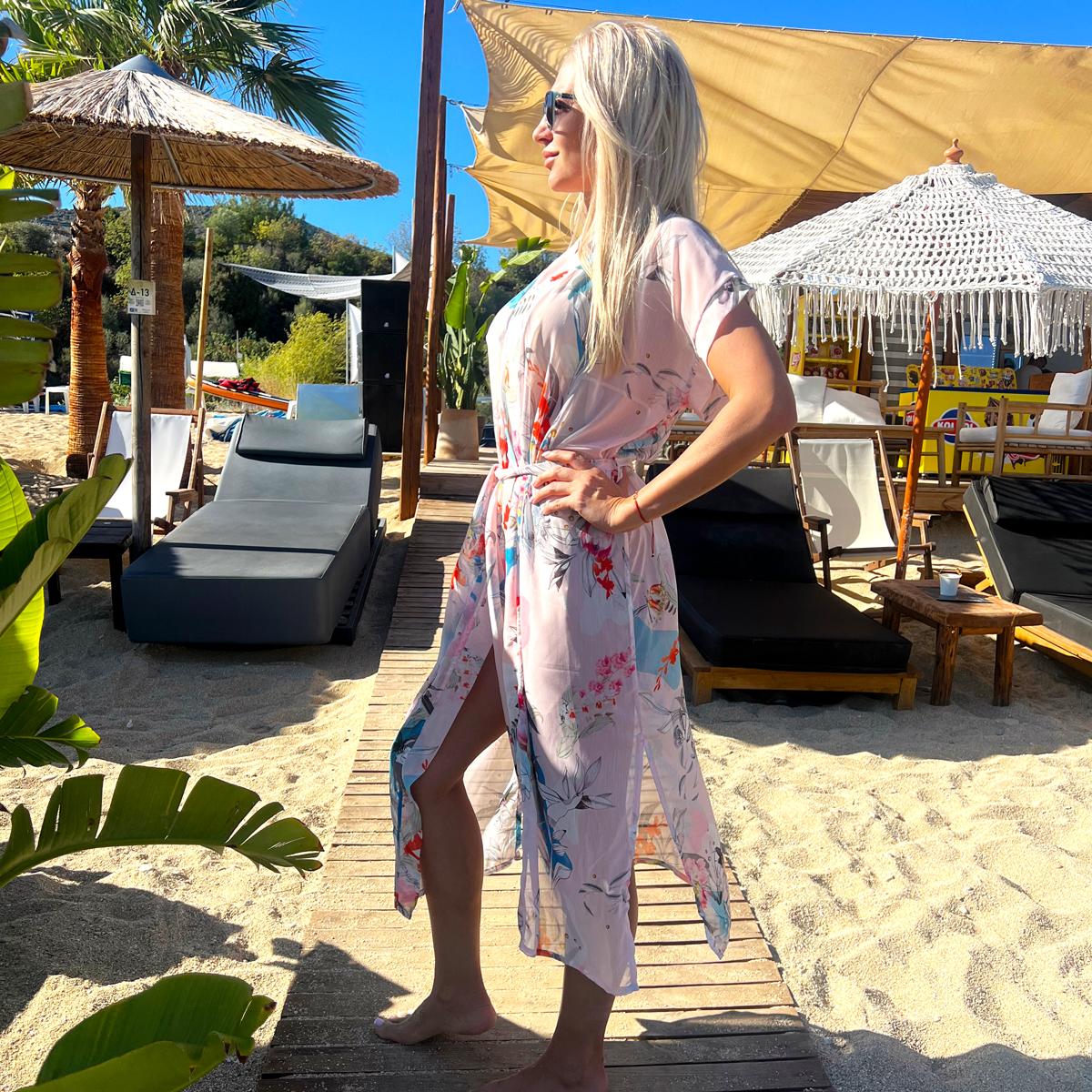 A blonde woman in chiffon long beach robe from Aria Fashion Brand