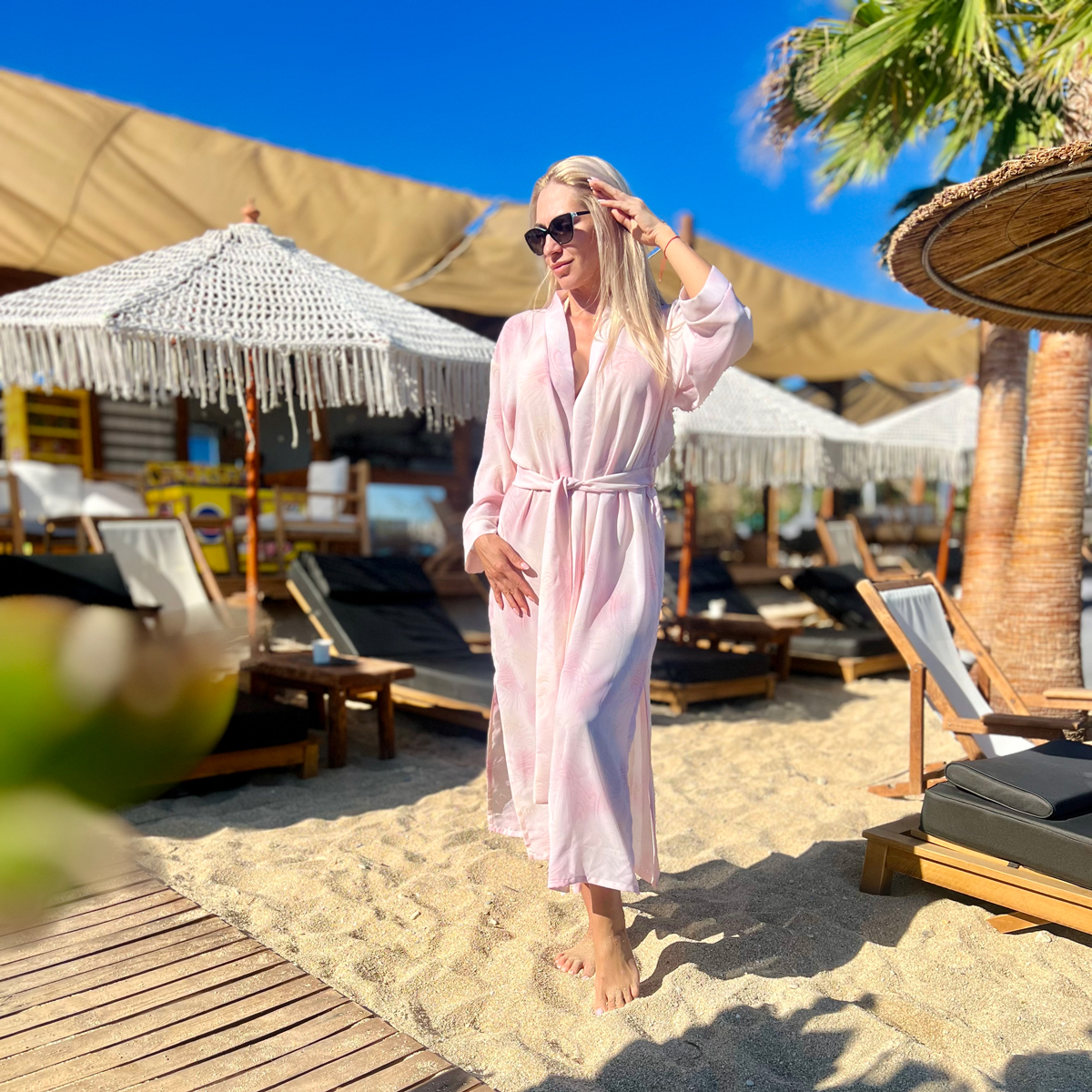 A blonde girl wearing pink beach robe from Aria Fashion Strore at a beach in Greece