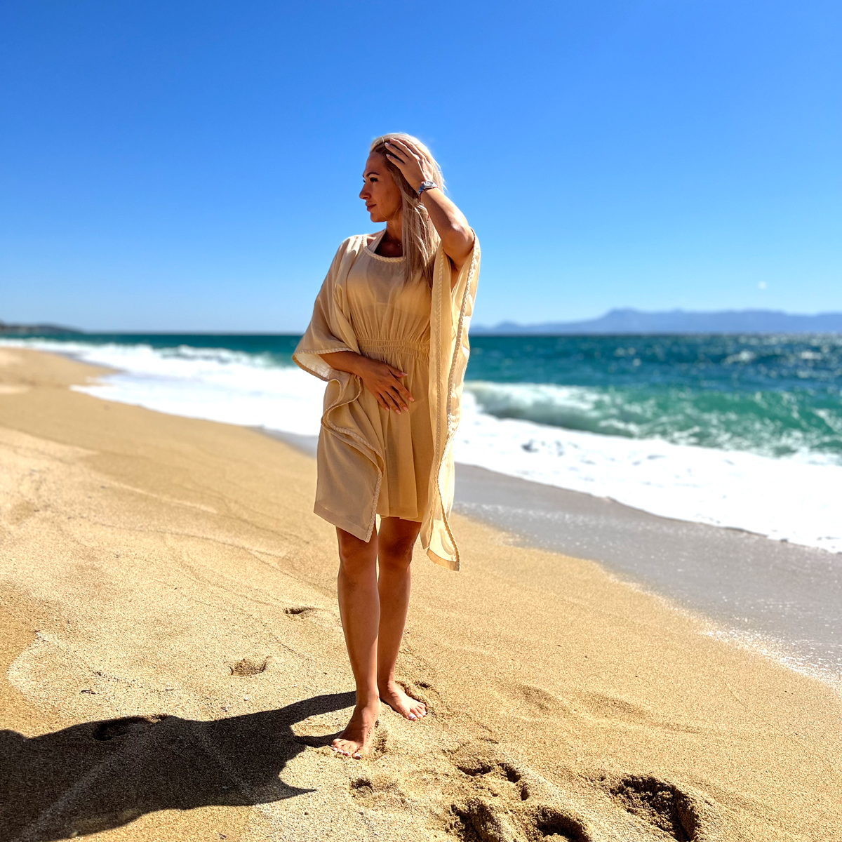 A girl at a beach with beige beach robe from Aira Fashion