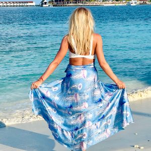 A blonde girl with blue jelly fish printed satin beach skirt in maldives